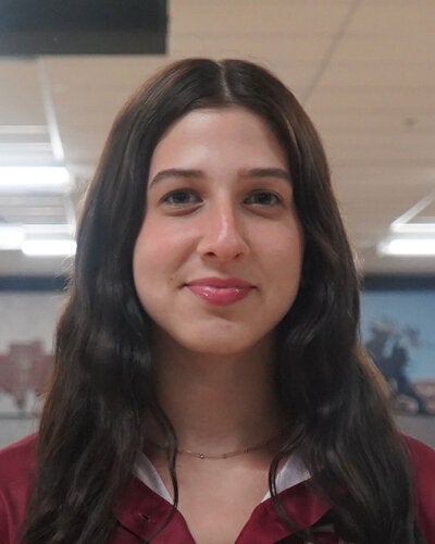 Photo of Caroline Geller - Female smiling wearing a garnet FSU polo shirt with FSU logo